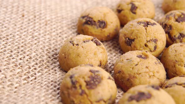 Small round dessert biscuits with chocolate chips on a rough rustic burlap. Macro