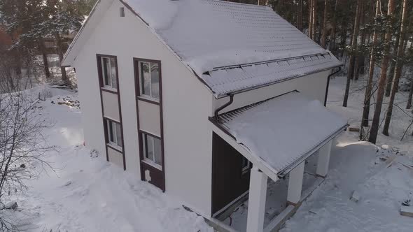 Drone shot of new white modern residential house at winter near the forest 06