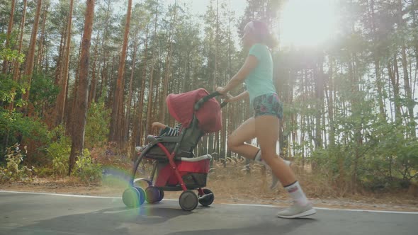 Running Woman with Baby Stroller on the Road in Forest