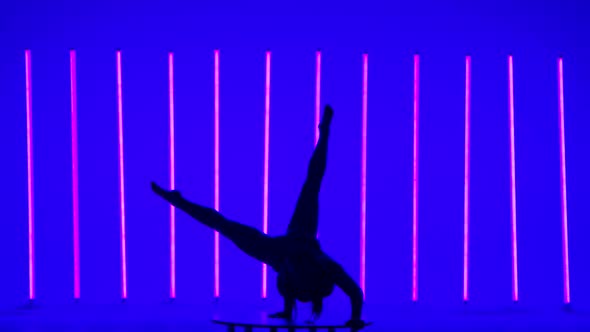 A Young Woman Performs a Handstand Does an Angle Splits Moves Her Legs and Bends Them at the Knees