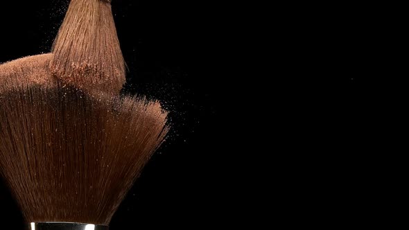 Make-up Brush spreading blush powder on black background, Slow motion
