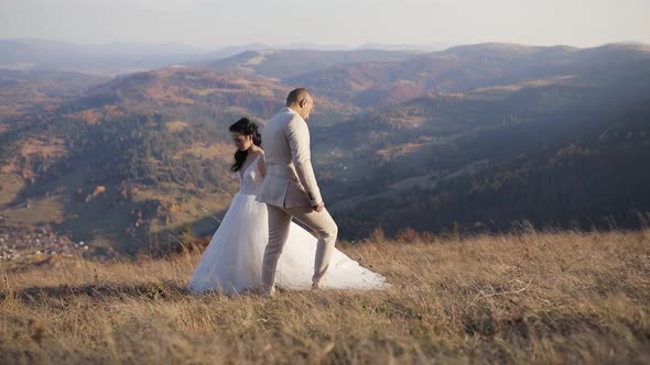 Husband and Wife Walk Past One Another Trying To Hold Hands in Autmn Mountains. Slow Motion.