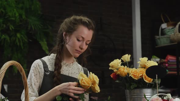 Girl Florist Collects a Bouquet of Roses