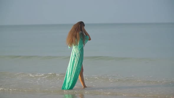 Woman in a Bathrobe Walking Along the Sea