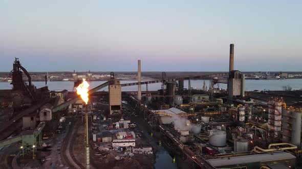 Zug Island Steel Factory, Steel mill in Detroit, Michigan aerial panning shot with burning chimney a