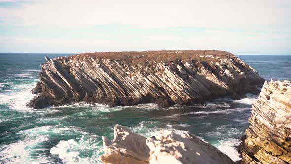 ocean waves break on the coastal rock.