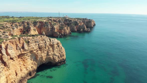 Farol Ponta da Piedade, lighthouse overlooking the Atlantic Ocean emerald waters, Lagos, Algarve