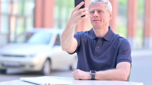 Outdoor Middle Aged Businessman Searching for Network on Smartphone