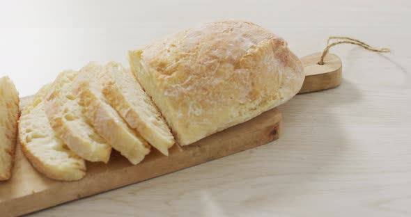 Video of bread on wooden chopping board seeing from above