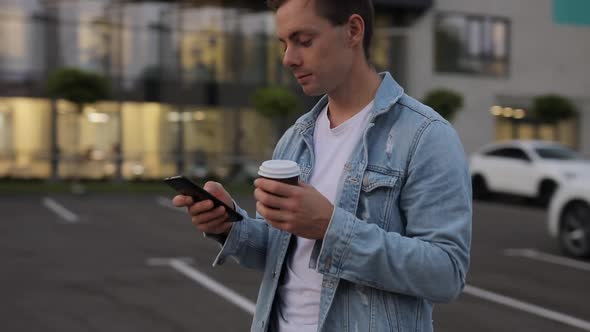 Man Walks with Smartphone in City