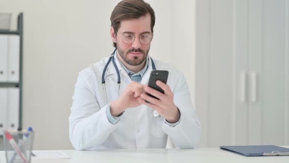 Young Male Doctor Using Smartphone Work
