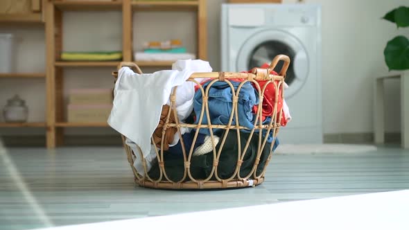 Prepared Basket with Dirty Casual Clothes on Floor of Bathroom with Washing Machine