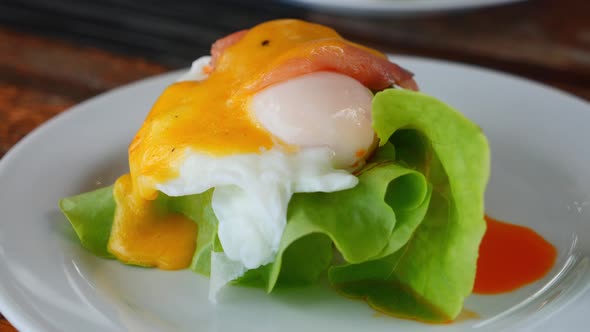 Closeup Rotating Shot of a Chef's Menu Dish on a White Plate with Softboiled Egg Windblown Green