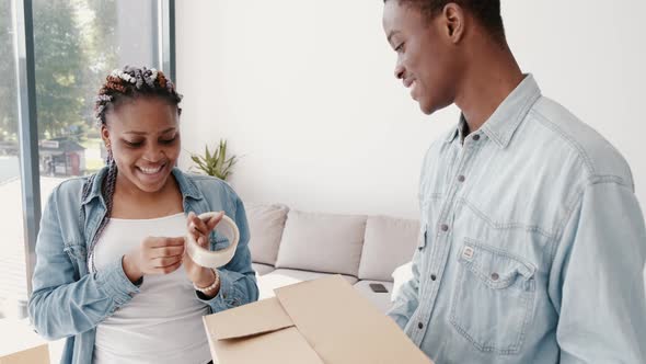 African- American Boyfriend and Girlfriend Are Packing a Box