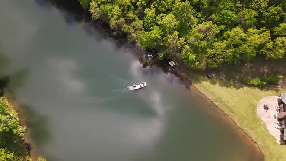 This is a slow shot of a boat coming to shore from a drone. It is shot in a beautiful part of Arkans