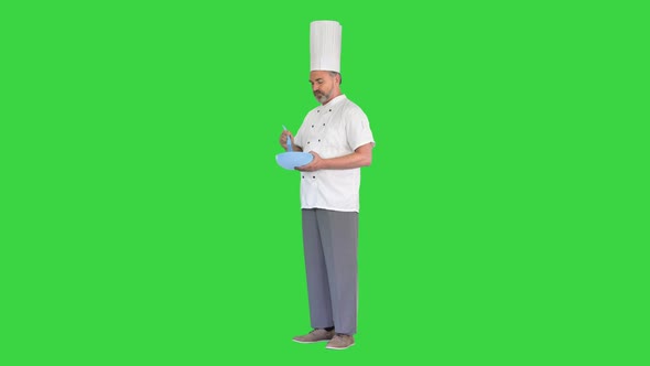 Male Chef Cook Holding Bowl and Whipping Something with Whisk on a Green Screen Chroma Key