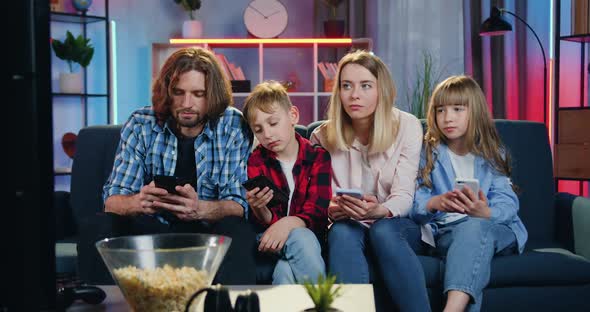 Family at Home and Applying Their Own Phones as there is Nothing to Watch on TV Set