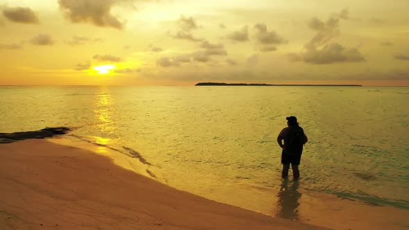 Girl happy and smiling on relaxing coastline beach vacation by turquoise lagoon and white sand backg