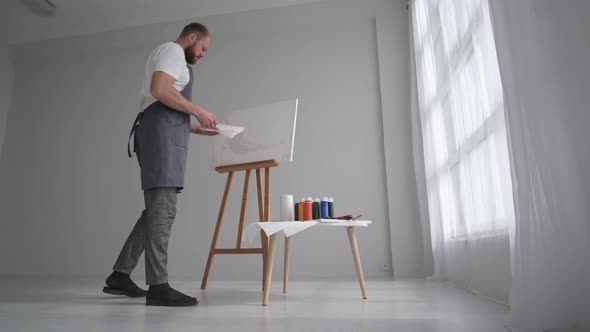 Male Artist Paints a Picture with Oil Paints Artist While Working in the Studio