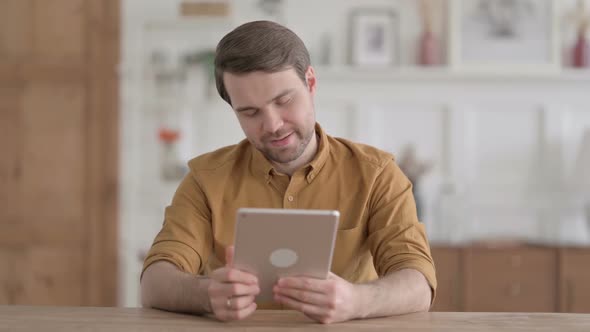 Young Man making Video Call on Tablet in Office