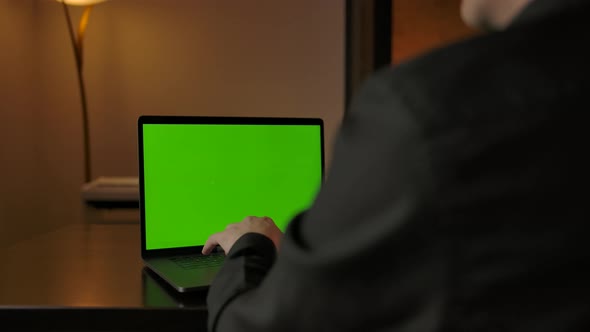 Man in VR Helmet Working at Home Behind Laptop with Green Screen