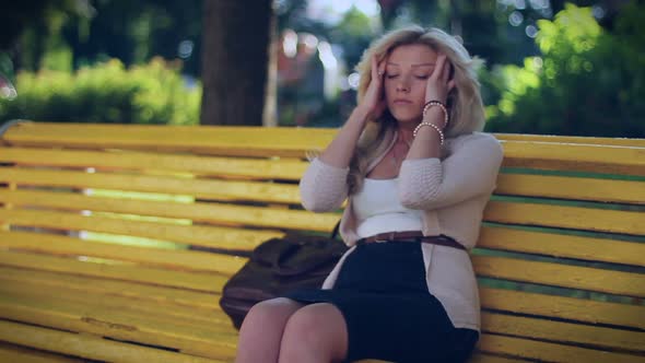 Problems at Work, Depression, Head Ache Young Woman Sits in Park