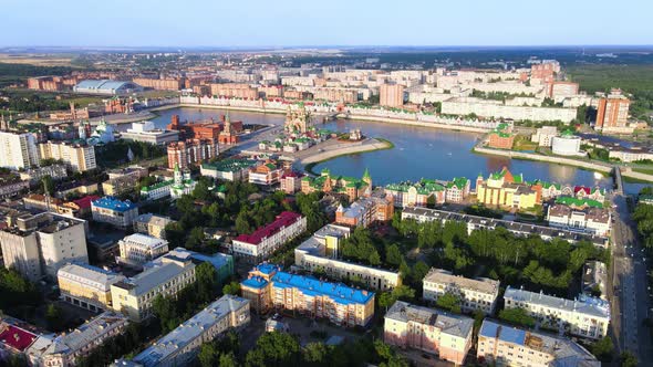 River, embankment, residential buildings at summer golden evening. Drone view