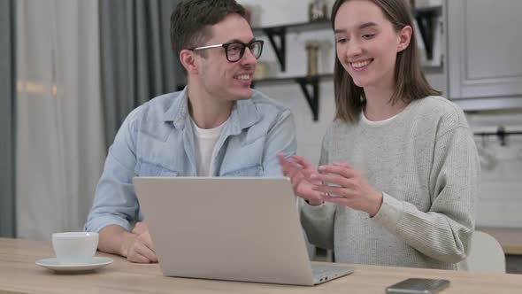 Online Video Chat on Laptop at Home By Cheerful Young Couple