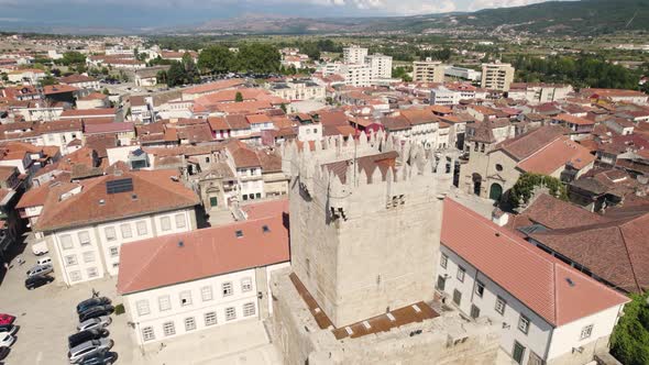 Aerial flying forward Passing Castle tower over historic downtown buildings, Chaves