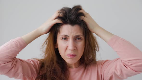 Unhappy Young Woman Scratches Head with Hands Caused By Dandruff