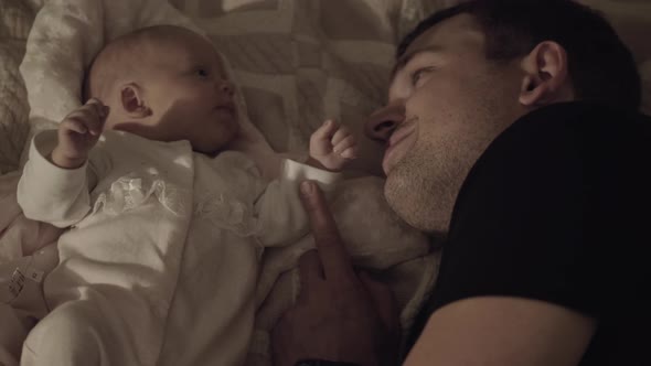 Dad with Beloved Baby Daughter Lying on Bed