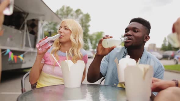 Friends with Food Clinking Drinks at Outdoor Table