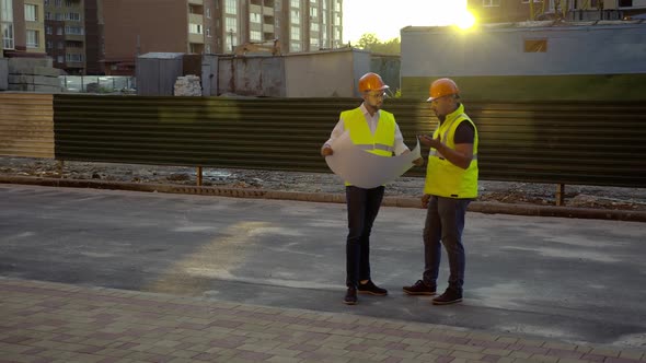 Two Workers Discuss Their Project and Look on It