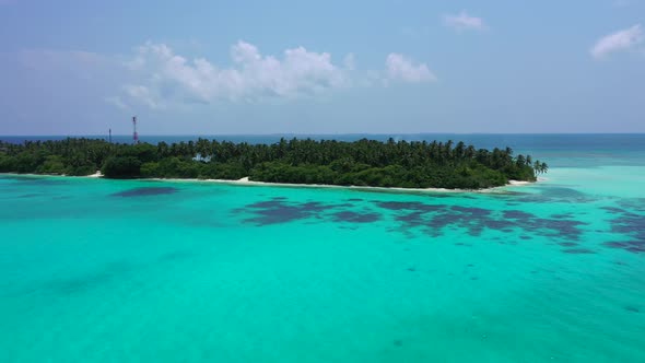 Wide overhead island view of a white sandy paradise beach and aqua blue water background in high res