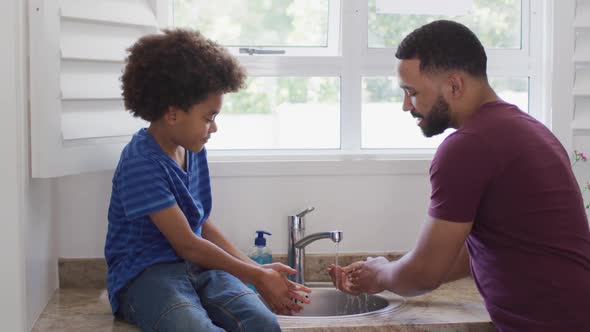 Father and son washing their hands in the sink