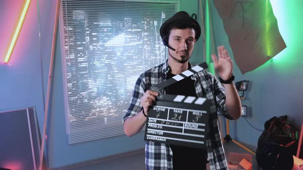 Portrait of Producer Assistant Smiling To the Camera and Giving Action with Movie Clapper Board.