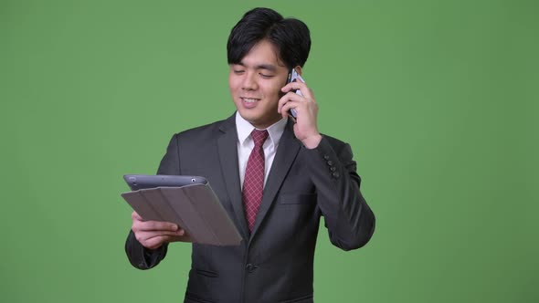 Young Handsome Asian Businessman Using Digital Tablet