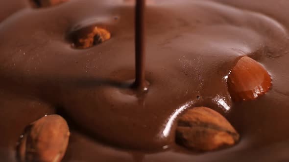 Close-up Shot of a Coating of Toasted Almonds and Hazelnuts with Melted Dark Chocolate