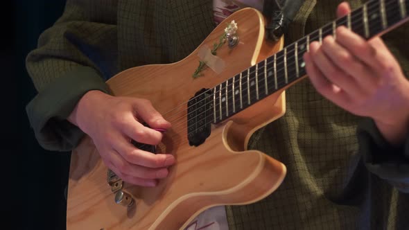 Jazz Guitarist in a Green Jacket Plays at a Concert