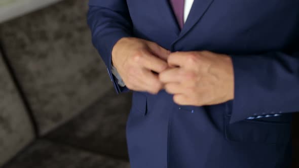 Businessman Buttoning a Button on His Blue Suit