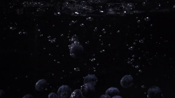 Tasty Fresh Blueberries Falling Into Water. Blue Wildberries in Slow Motion Underwater. Food Video