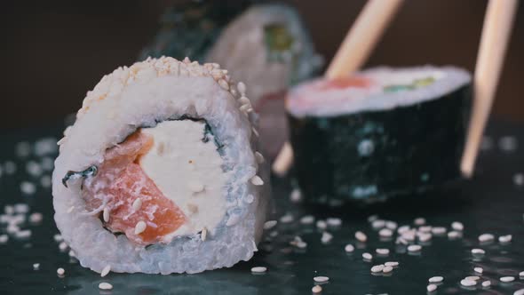 Fresh Sushi Roll with Sesame is Placed with Special Japanese Chopsticks