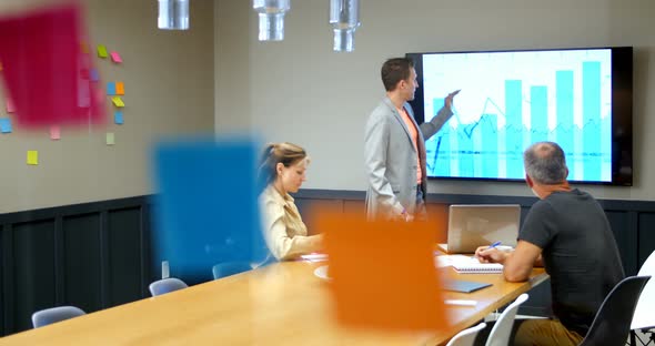 Businessman discussing with colleagues over lcd screen in conference room 4k