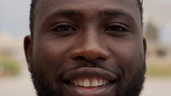 Outdoor Portrait of an AfricanAmerican Man Looking at the Camera Smiling