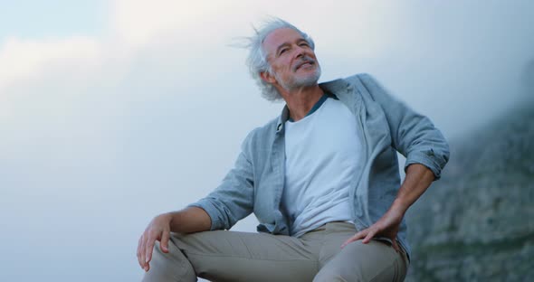 Senior man relaxing on a rock at countryside 