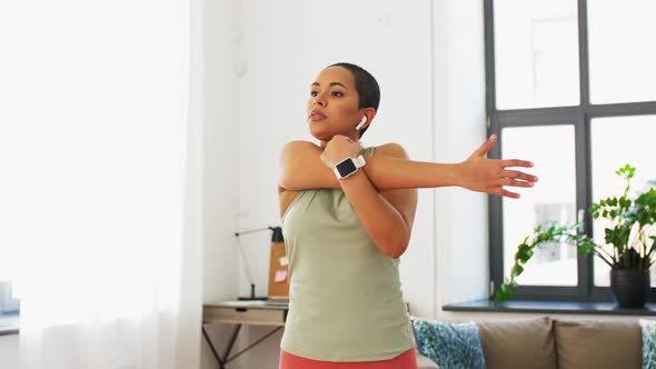 Woman with Smart Watch Stretching Arm at Home