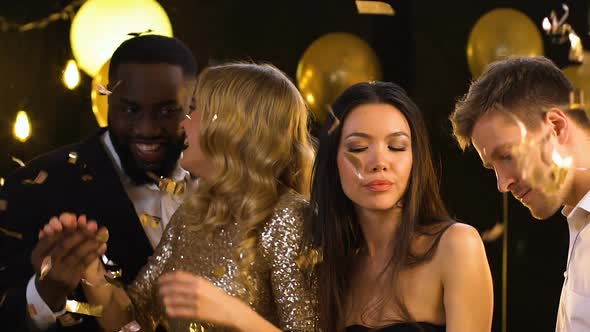 Smiling Multiracial Couples Dancing at Party Under Falling Confetti, Happiness