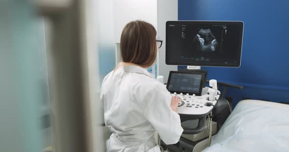 Operator of Ultrasound Scanning Machine Sitting and Looking at the Screen