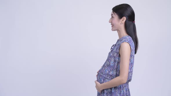 Profile View of Happy Beautiful Pregnant Asian Woman Smiling