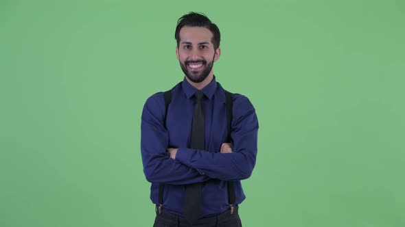 Happy Young Bearded Persian Businessman Smiling with Arms Crossed